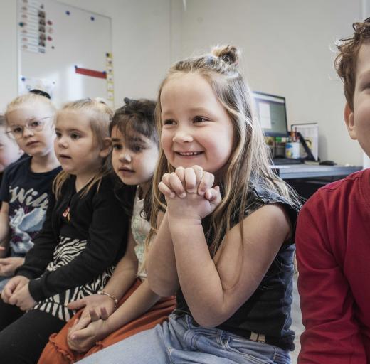 Valerie lachend in een klaslokaal, met naast haar andere kinderen