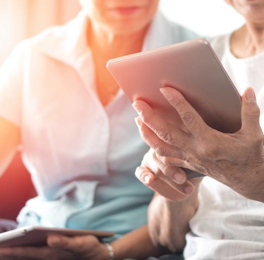 Foto van vrouw met tablet die hulp krijgt bij het gebruik ervan